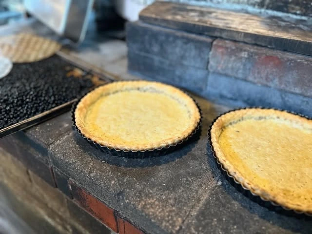 薪窯の前で焼かれるタルト